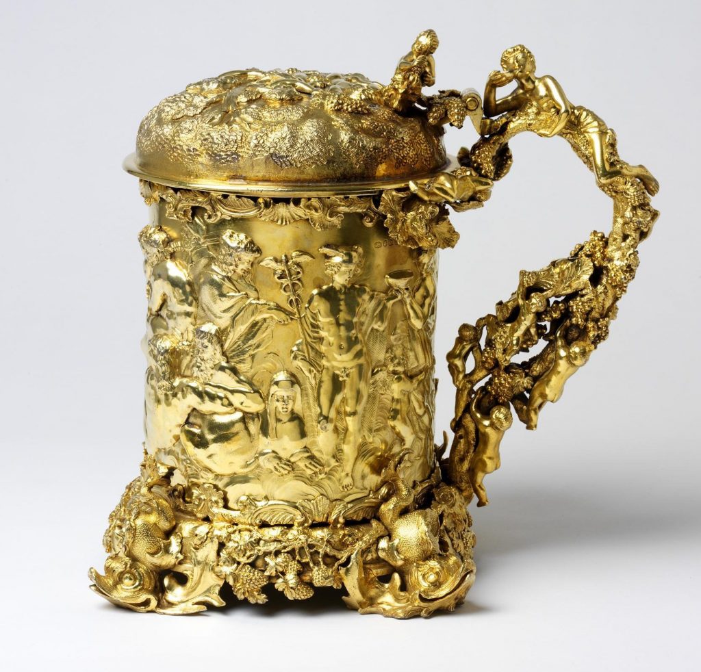 Cylindrical tankard, the base with applied grapevine and dolphin feet,