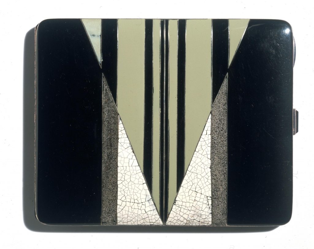 Slim rectangular case with hinged lid, decorated with a geometric pattern in green, black and white.