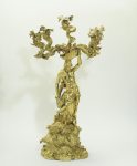 Silver gilt four branched candelabrum formed by the figure of Neptune astride a hippocamp on a rocky base holding the candelabrum branches in the form of a four winged hydra springing forth from a shell.