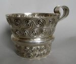 Silver cup of flared form with central bulge and applied strap handle