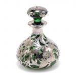 Green perfume bottle featuring a silver flower overlay
