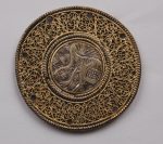 Belt-fitting; silver, silver gilt, traces of enamel; circular; the central medallion engraved with the figure of a fantastical bird; the outer border of filigree