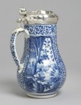 Tankard with pear-shaped body decorated in underglaze blue; three reserved panels divided by floral scrolls painted with landscapes,