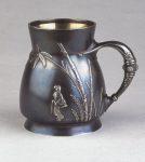 Tankard; silver and oxidised silver, in the Japanese taste, decorated with applied silver motifs of figures